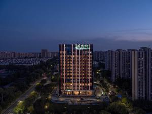 a tall building with a sign on top of it at Holiday Inn Beijing Daxing Centre by IHG in Beijing