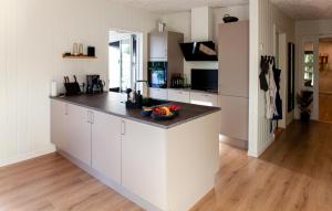 a kitchen with white cabinets and a black counter top at Amazing Home In Glesborg With Sauna in Fjellerup Strand