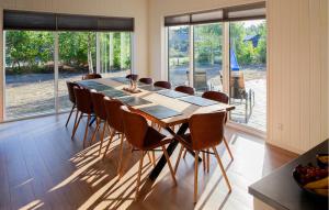 a dining room with a long table and chairs at Amazing Home In Glesborg With Sauna in Fjellerup Strand