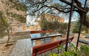 una mesa y bancos con vistas al océano en 2 Bedroom Lovely Apartment In Veliko Brdo, en Veliko Brdo 11 fotos más