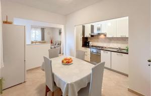 Una cocina con una mesa con un bol de fruta encima. en 2 Bedroom Lovely Apartment In Veliko Brdo, en Veliko Brdo
