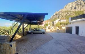 un coche aparcado en un aparcamiento frente a una montaña en 2 Bedroom Lovely Apartment In Veliko Brdo, en Veliko Brdo