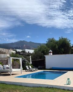 una piscina con cenador y sillas junto a en Casa Deco, en San Borondón