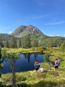 un gruppo di persone in piedi accanto a un piccolo lago di by franz a Kirchberg in Tirol
