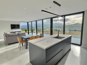 a kitchen with a sink and a table with chairs at The Waterboard House in Magherasaul