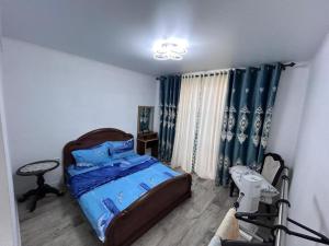 a bedroom with a bed and a chair in it at Милый дом in Tokmok +3 photos