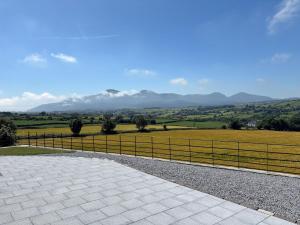 a view of a field with mountains in the background at The Waterboard House in Magherasaul