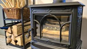 an old wood stove with a basket of wood at dziupla in Górki Wielkie