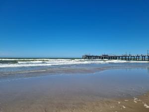 a view of the beach with a pier in the background at Chalet Angelica Las Toninas in Las Toninas