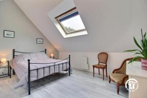 Un dormitorio con una cama y una claraboya. en Hoedic, en Surzur
