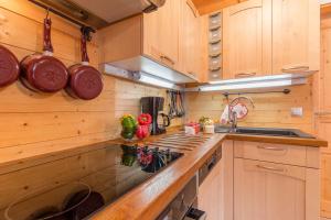a kitchen with wooden cabinets and a stove top oven at Rdc 110 m2 - Très proche des pistes in La Toussuire