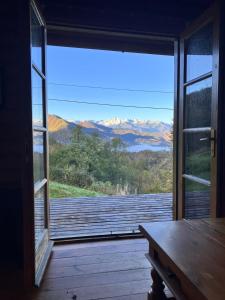 an open door to a porch with a view of the mountains at Gîte de montagne Las Trinquades in Boussenac