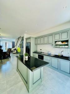 a large kitchen with blue cabinets and a living room at lalahouse6 in Khu Chi Lăng