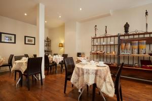 a restaurant with tables and chairs in a room at Hotel Antin St Georges in Paris