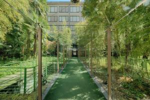 a walkway in front of a building with trees at NH Torino Lingotto Congress in Turin +44 photos