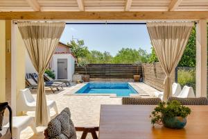 a patio with a pool and a table and chairs at House Crassula in Murter