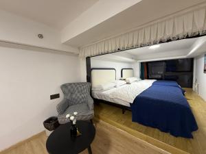 a bedroom with a king sized bed and a chair at Spark Hotel & Serviced Apartments in Shenzhen +30 photos