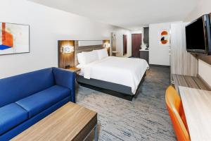 a hotel room with a bed and a couch at Holiday Inn Express Hotel & Suites Dumas by IHG in Dumas