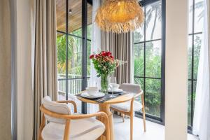 a dining room with a table and chairs and a chandelier at Cascade 5 - Tropical 1BR Hideaway with Garden View in Ubud in Ubud
