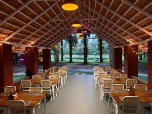 a row of tables and chairs in a building at Nomad's Nook in Ponnampet