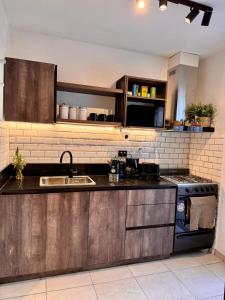 een keuken met een spoelbak en een fornuis bij Calma 1939 in Villa Carlos Paz