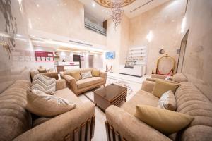 メッカにあるOrvana Al Naseem Hotelのソファと椅子付きの広いリビングルーム
