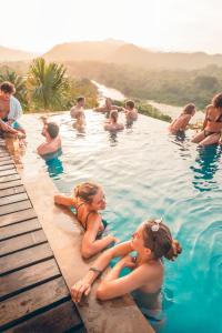 un grupo de personas sentadas en una piscina en The Journey Hostel, en Los Naranjos