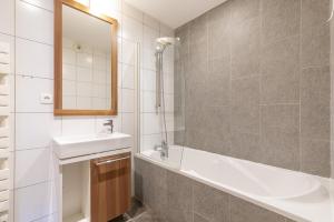 a bathroom with a sink and a tub and a mirror at Résidence Les Portes du Grand Massif - Flaine in Flaine