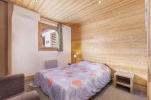 a bedroom with a bed in a wooden wall at Résidence Les Portes du Grand Massif - Flaine in Flaine