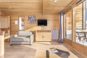 a living room with a chair and a television at Résidence Les Portes du Grand Massif - Flaine in Flaine