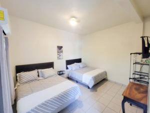 a bedroom with two beds and a table in it at Hotel Sweet Dreams in La Unión