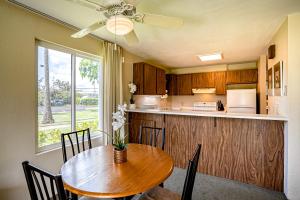 une cuisine avec une table en bois et une salle à manger dans l'établissement Pono Kai Resort J101, à Kapaa