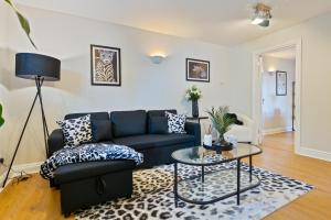 Una sala de estar con un sofá azul y una mesa de cristal. en The Tudor Escape Stylish City Centre 3 Bed, en Canterbury