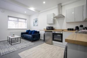eine Küche und ein Wohnzimmer mit einer Couch und einem Tisch in der Unterkunft Bespoke Apartments Near Cardiff City Centre Free Parking in Cardiff