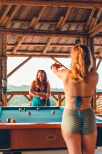 a woman in a bathing suit playing a game of pool at The Journey Hostel in Los Naranjos