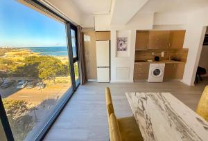 a kitchen and dining room with a view of the ocean at Maritimo ApartHotel in Constanţa