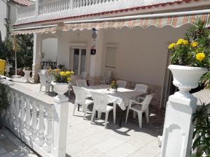 a white fence with a table and chairs on a patio at Mile Ferienhaus-excellent location close to Rab in Rab