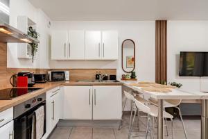 a kitchen with white cabinets and a table with chairs at Annecy gare in Annecy +9 photos