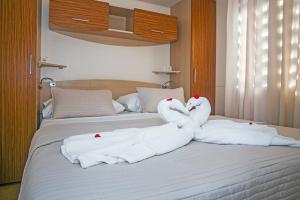 two swans are made out of towels on a bed at Auto-kamp Dvije suze 1 in Brištane