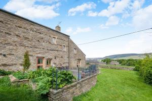 an old stone house with a garden in front of it at 4 Bed in Burtersett oc-h32270 in Hawes