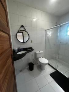 a bathroom with a toilet and a glass shower at Casa dos Corais in Cabo de Santo Agostinho
