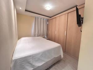 une petite chambre avec un lit blanc et une télévision dans l'établissement Apartamento simone 2 COP 30, à Água Boa