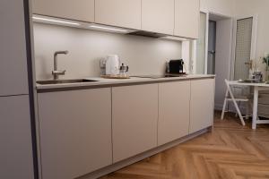a kitchen with white cabinets and a sink at Casa Lilla in Varese
