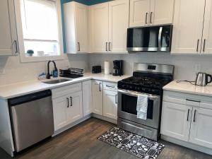 a kitchen with white cabinets and a stove top oven at Peace Haven Stay in Newark