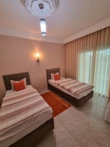 a bedroom with two beds and a chandelier at Ferienwohnung Nabeul in Douane
