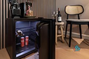 een open koelkast in een kamer met een tafel en stoelen bij Bright King Room with Shared Bathroom at Amsterdam Zuid in Amsterdam