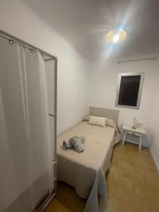 ein kleines Schlafzimmer mit einem Bett und einem Fenster in der Unterkunft La Casita in El Real de la Jara