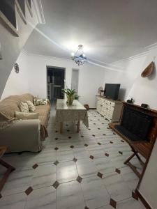ein Wohnzimmer mit Sofa und Tisch in der Unterkunft La Casita in El Real de la Jara