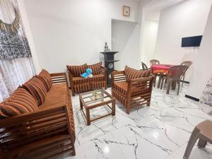 a living room with wooden chairs and a table at Freedom Villa in Hikkaduwa