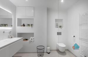 een witte badkamer met een toilet en een wastafel bij Bright King Room with Shared Bathroom at Amsterdam Zuid in Amsterdam